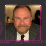 Happy smiling face of Simon Burton currently with facial hair - smart moustache and beard combo, with smart tie and shirt suit attire profile photo